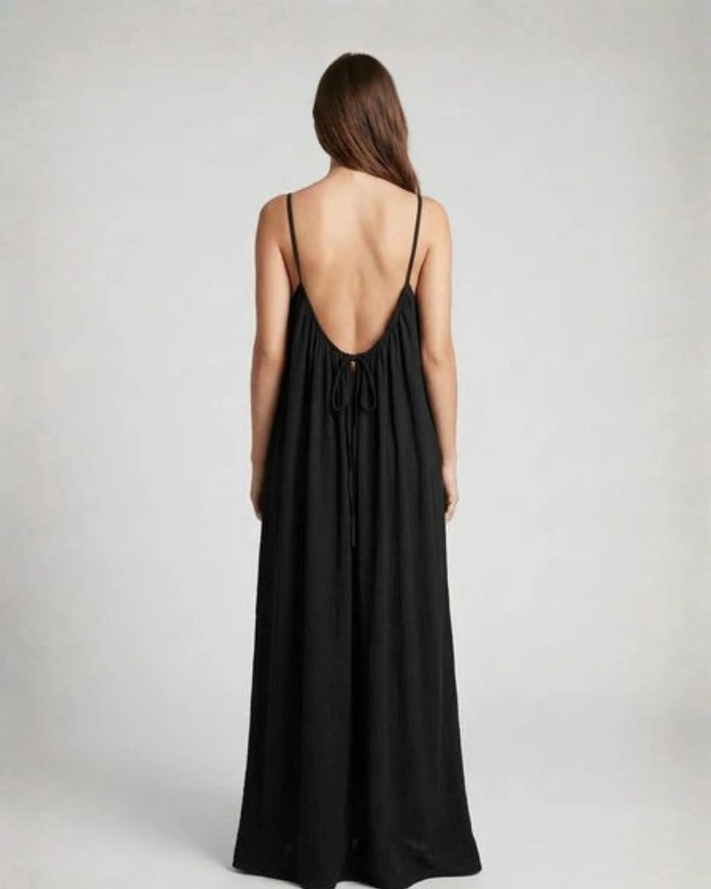Woman wearing a Backless Loose Home Long Dress in black, showcasing a relaxed and stylish look.