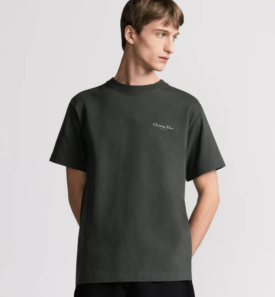 Man wearing Dior black t-shirt with a logo on a light gray background