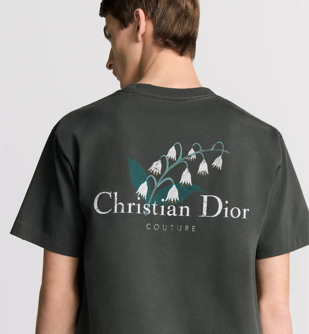 man wearing a black Christian Dior t-shirt with floral design on the back.