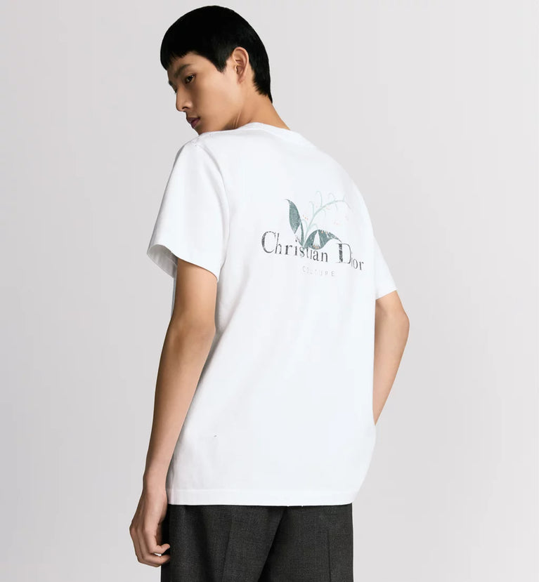 man wearing Christian Dior Couture white t-shirt with a logo on the back against a plain background