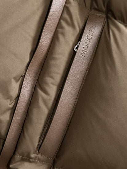 Close-up of a brown Moncler jacket with a strap.