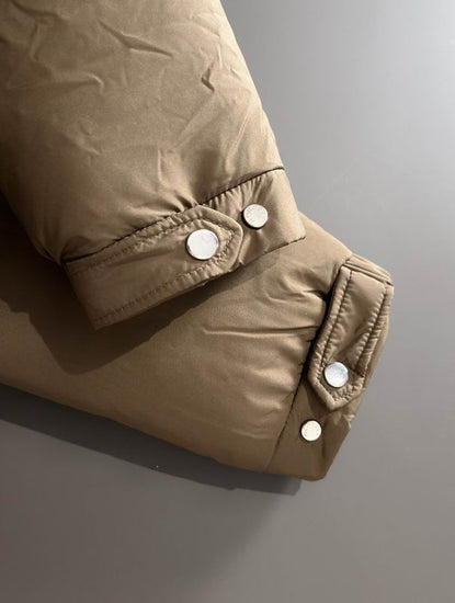 Close-up of a brown jacket with button details on a gray background