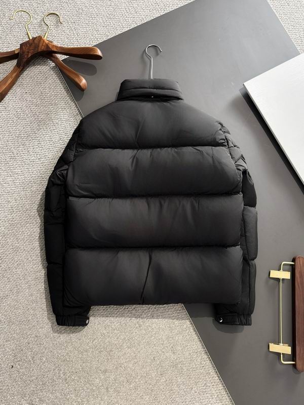 Black puffer jacket on a hanger against a gray background