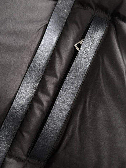 Close-up of a black jacket with a visible brand logo on a dark background