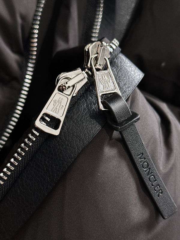 Close-up of a black Moncler bag with silver zippers and logo. Moncler Men's Besbre Padded Jacket