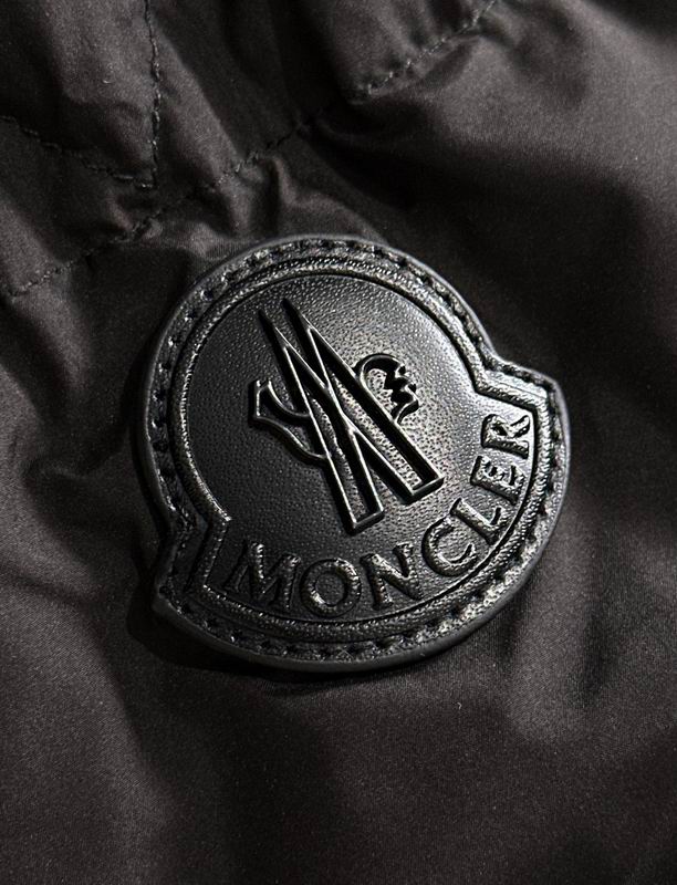 Close-up of a Moncler logo on a black fabric background