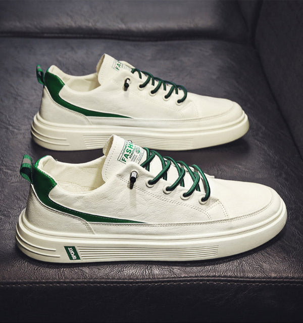 White sneakers with green accents on a dark surface