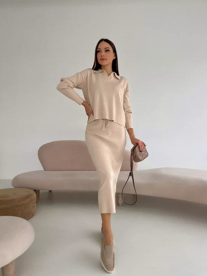 Woman in a beige outfit standing in a minimalistic room with a neutral color palette. Chic Elegant Soft Knit Sweater with Skirt Set