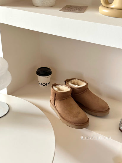 Brown UGG boots on a white shelf with a coffee cup in the background