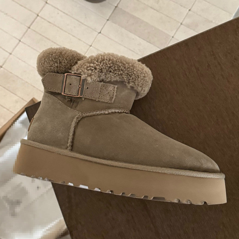 Beige suede boot with fur trim and buckle on a wooden floor. UGG Furry Belted Women's Snow Boot with Thick Platform Sole at Volonka