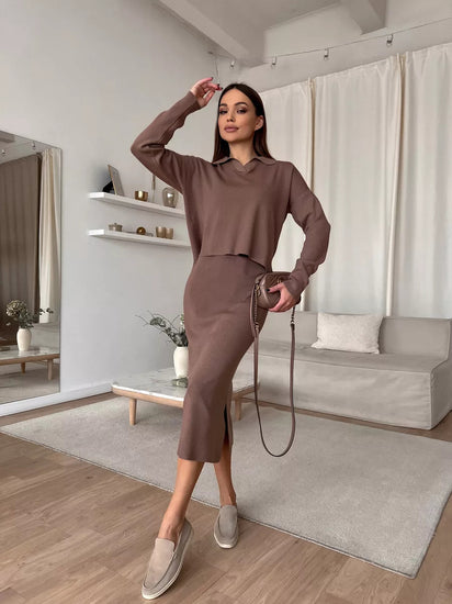 Woman in a brown outfit standing in a modern living room.