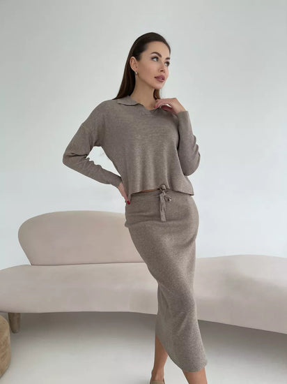 Woman wearing a brown outfit sitting on a white couch against a white background
