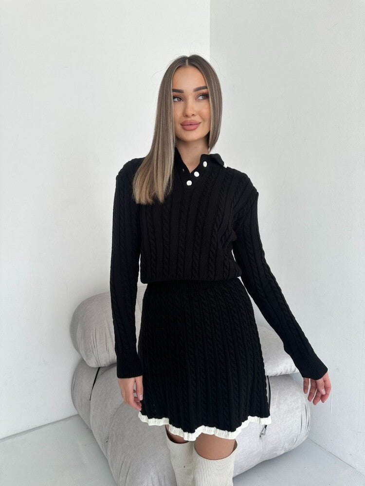 Woman wearing a black ribbed sweater and skirt set in a minimalistic setting.