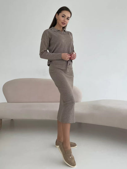 Woman wearing a brown outfit standing against a plain background