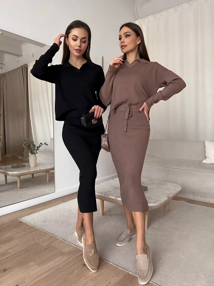 Two women posing in a modern interior setting wearing black and brown outfits.