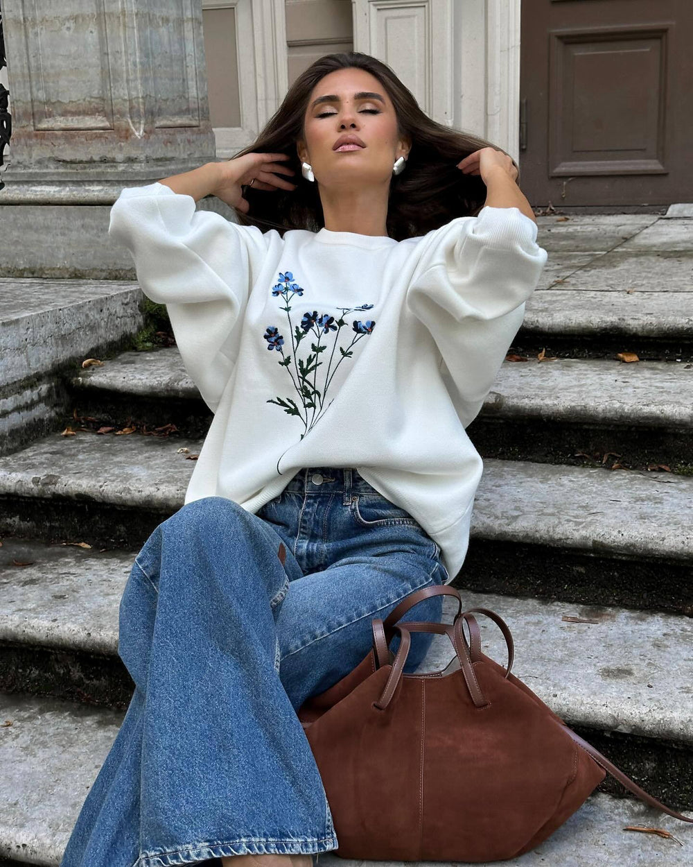 Woman wearing Women's Autumn Winter Thin Overhead Casual Sweater with floral design, sitting casually on steps.