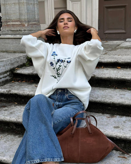 Woman wearing Women's Autumn Winter Thin Overhead Casual Sweater with floral design, sitting casually on steps.