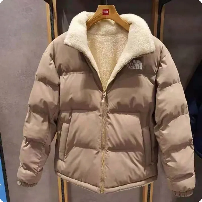 The NorthFace Two Sided Coat for Women and Men. Beige puffer jacket with white fur lining on a hanger.