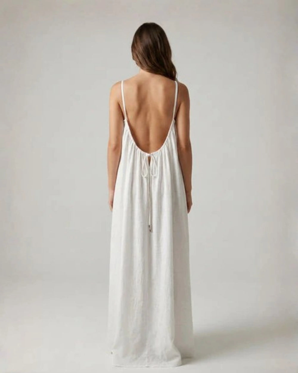 Woman wearing a Backless Loose Home Long Dress in white, showcasing a relaxed and stylish look.