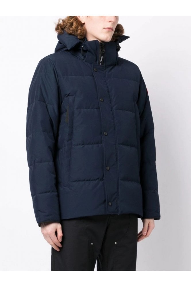 Person wearing a navy blue puffer jacket on a white background. Women's/ men Canada Goose Wyndham Parka with Fur jacket