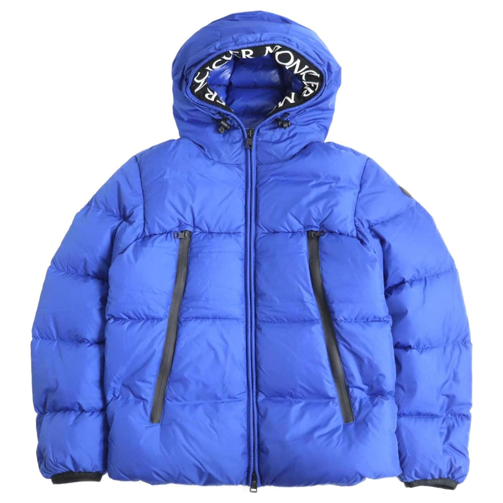 Blue puffer jacket with brand logo on hood against a white background. Moncler Montcla Short Down Jacket