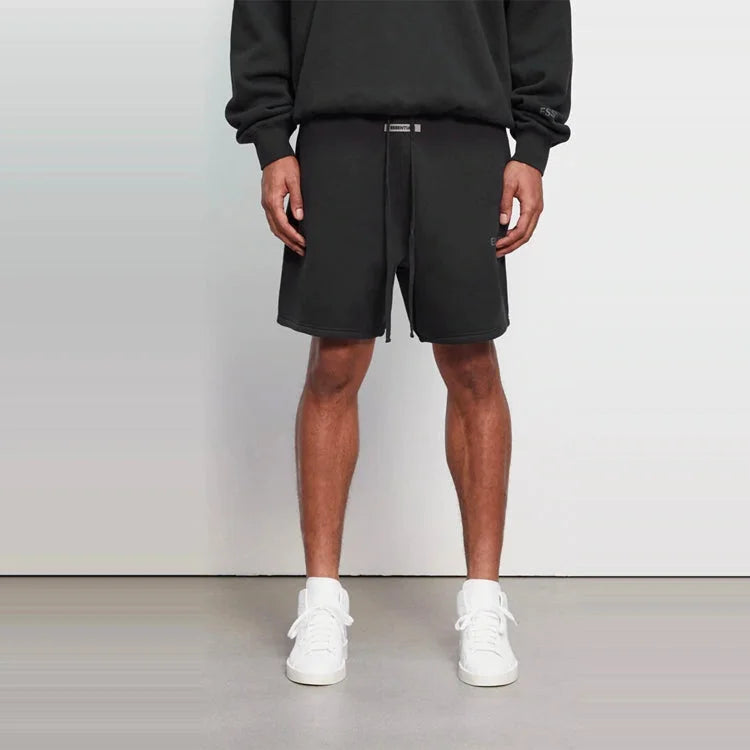 FEAR OF GOD ESSENTIALS sweatshort in Black with adjustable drawstrings and logo details.