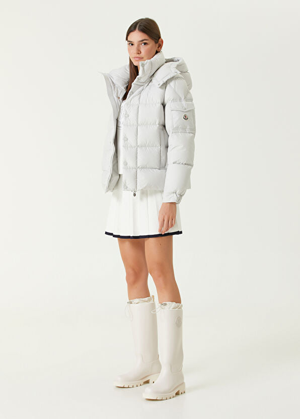 Woman wearing a white puffer jacket and boots. Moncler Maya 70 Hooded Short Down Jacket at Volonka
