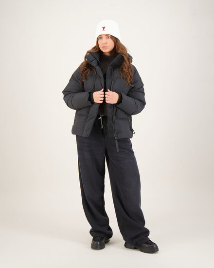 Woman wearing a dark gray winter coat, black pants. Canada Goose Junction Parka Black Label Unisex Winter Jacket