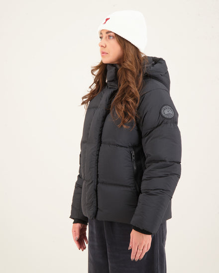 Woman wearing a black puffer jacket and white beanie. Canada Goose Junction Parka Black Label Unisex Winter Jacket