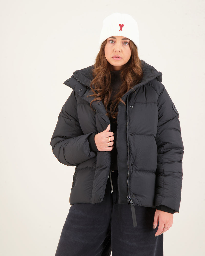 Woman wearing a black puffer jacket and white beanie with a red heart. Canada Goose Junction Parka Black Label Unisex Winter Jacket at volonka