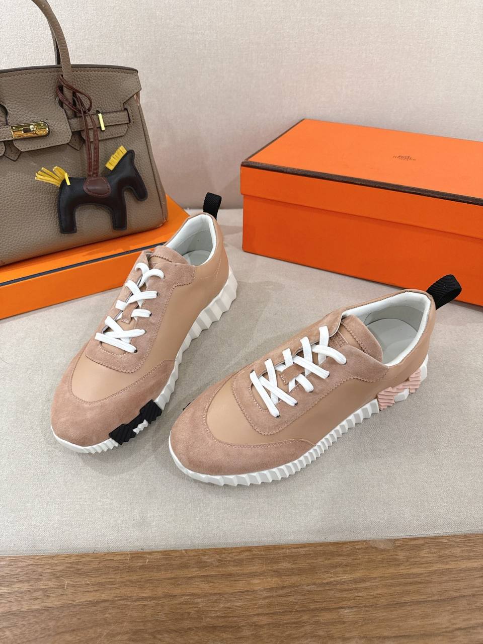 Hermes Unisex Bouncing Sneakers in pink suede with white laces and unique sole design.