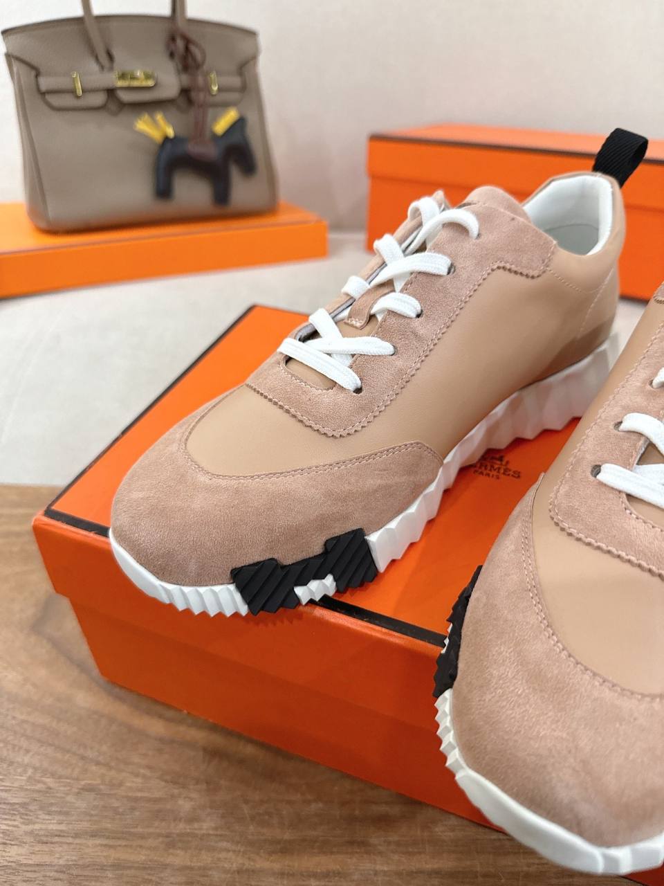 8Hermes Unisex Bouncing Sneakers in pink suede with white laces and unique sole design.