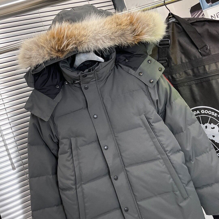 Gray winter coat with fur-lined hood on a stand, with a visible brand logo. Women's/ men Canada Goose Wyndham Parka with Fur jacket