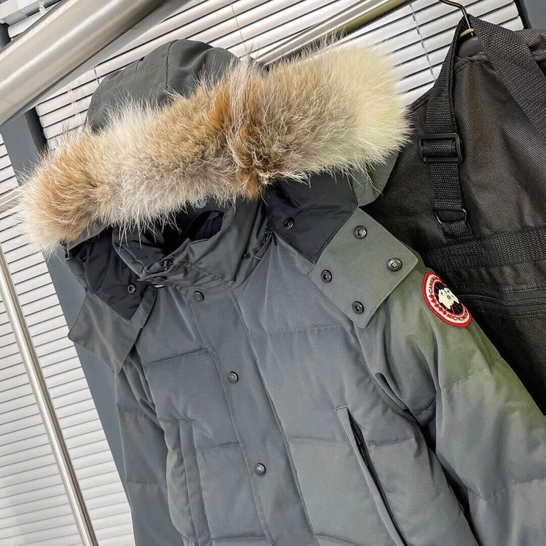 Gray parka with fur hood and a brand patch on a hanger. Women's/ men Canada Goose Wyndham Parka with Fur jacket